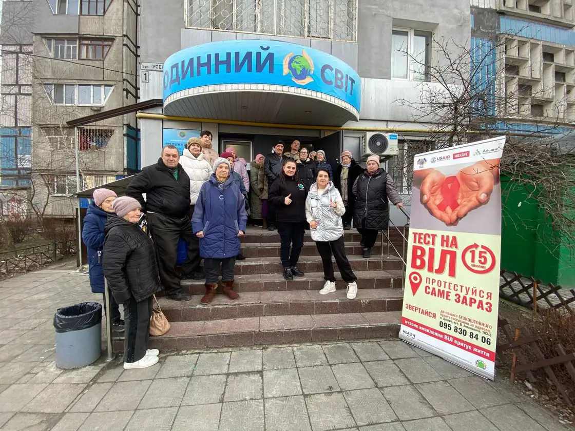 Люди на сходах біля офісу фонду поряд із інформаційним банером