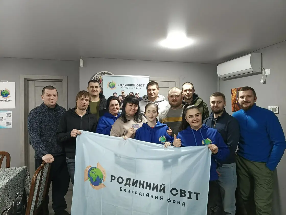Групове фото команди й волонтерів із прапором фонду