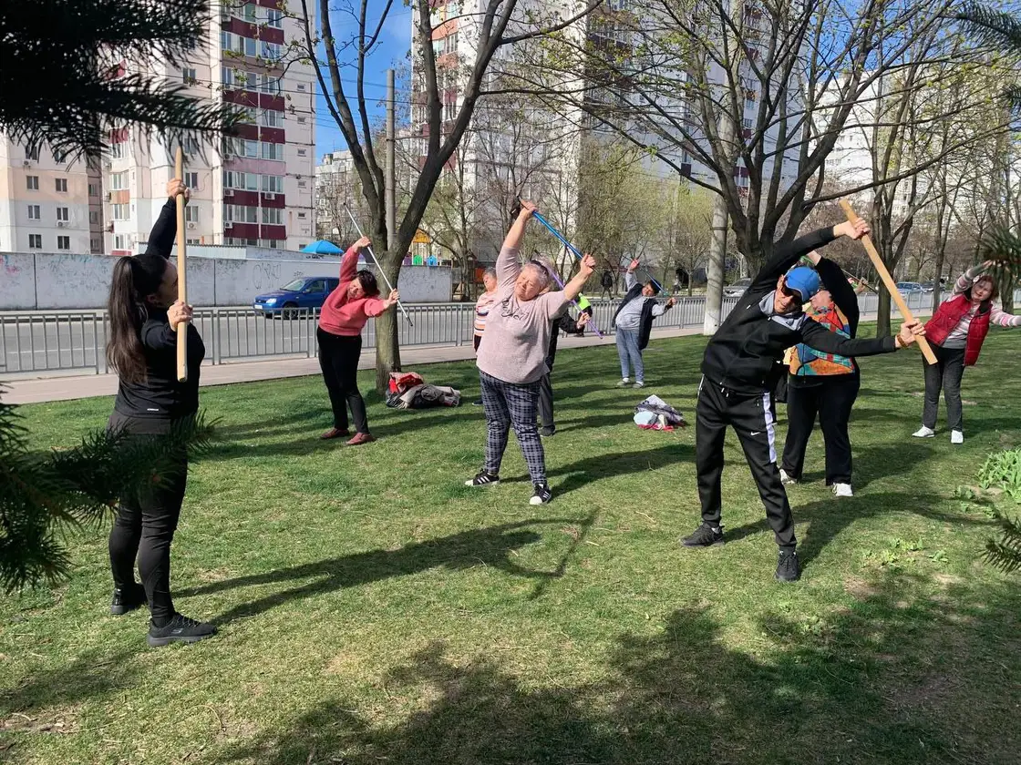 Заняття фізкультурою з гімнастичними палицями в парку