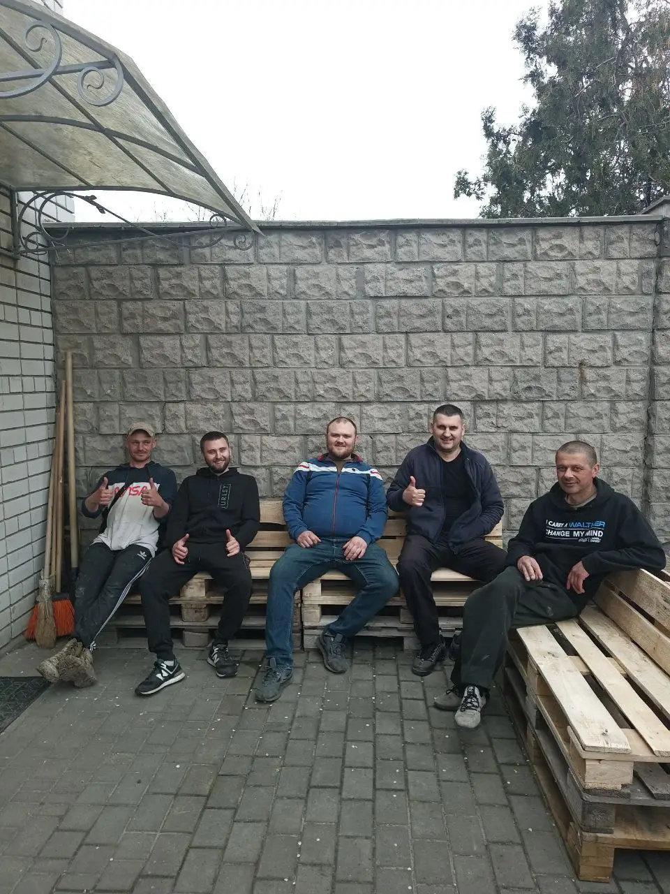Волонтери відпочивають після роботи з деревʼяними піддонами