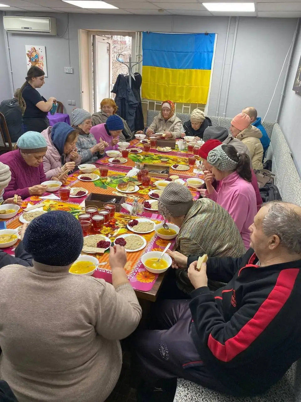 Обід у приміщенні з українським прапором на стіні
