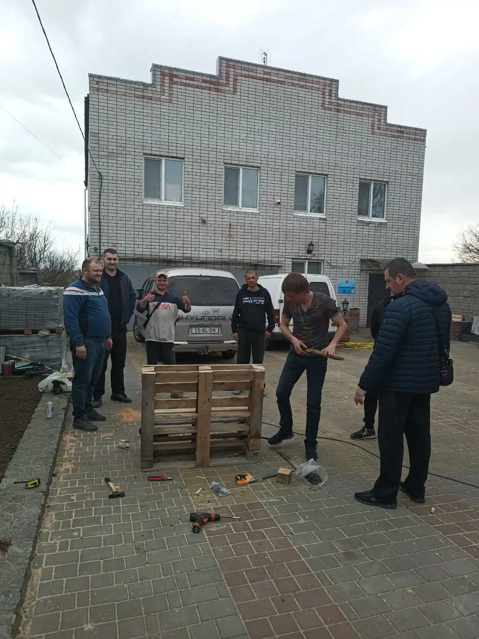 Волонтери майструють меблі з піддонів на подвірʼї